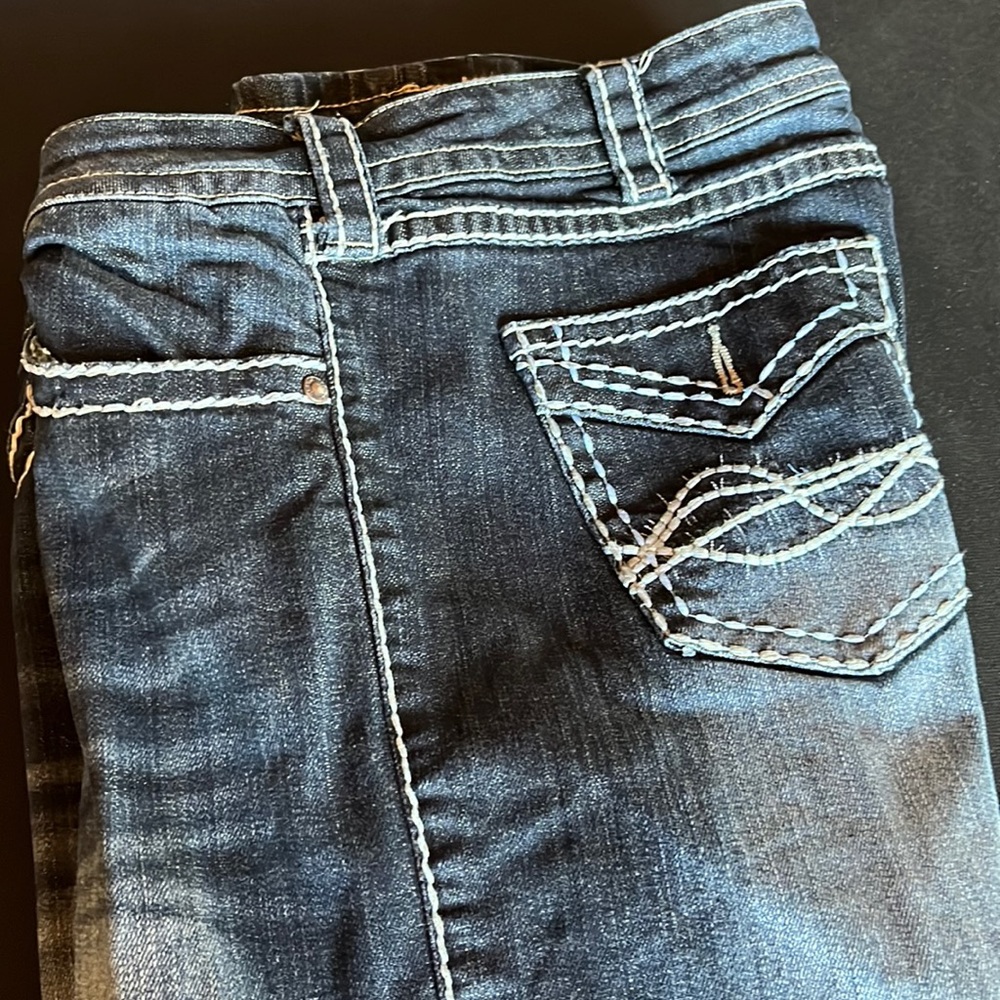 Cowgirl Tuff dark wash jeans. Missing one faux button on back pocket